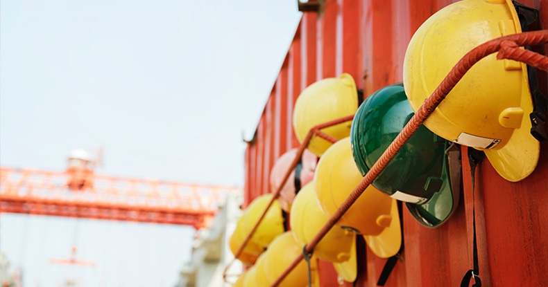 Hard hats hanging on the side of a shipping container